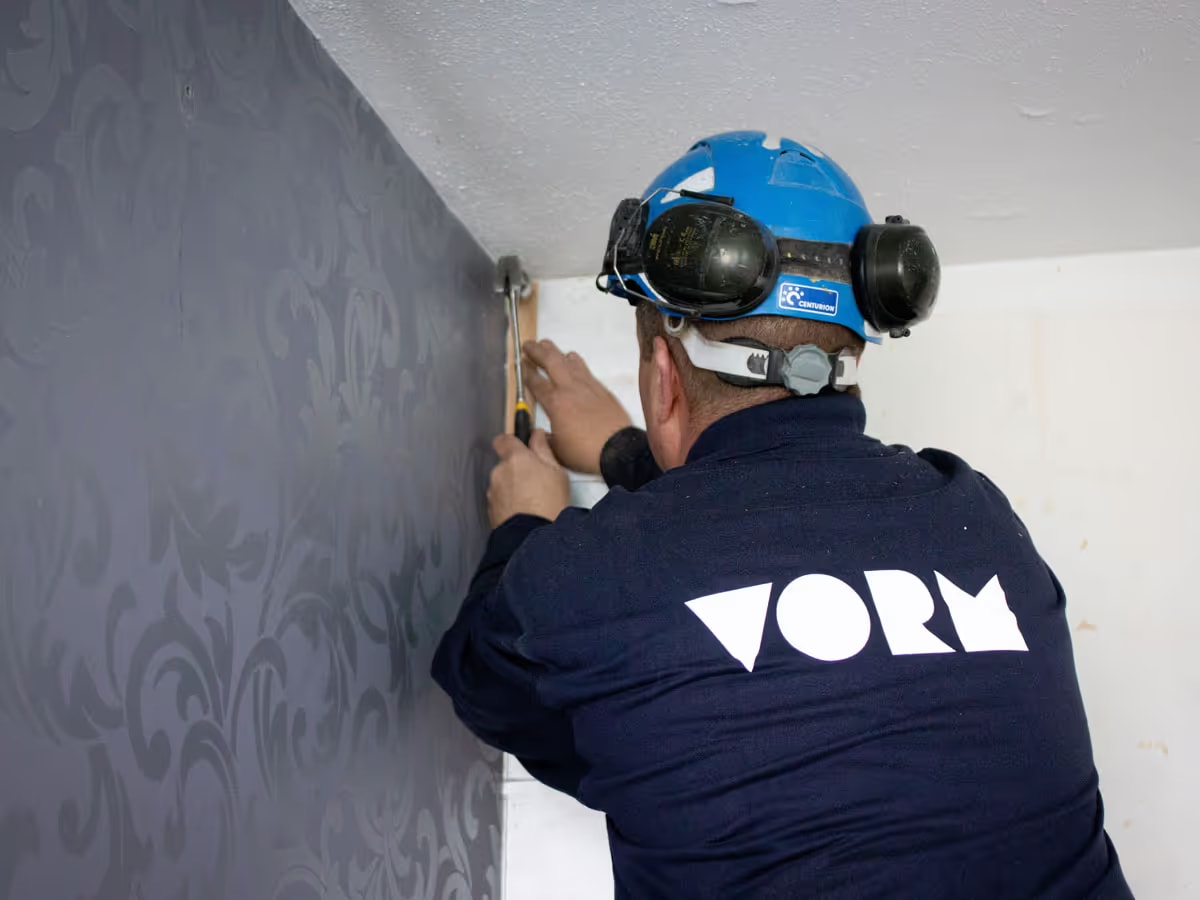 Bouwer gebruik gereedschap bij een muur