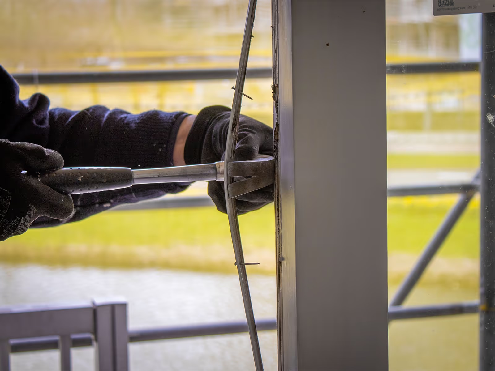 Bouwer gebruikt gereedschap bij raam